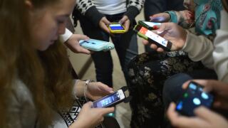 File photo: Teenagers using smart phones, children kids cell phones